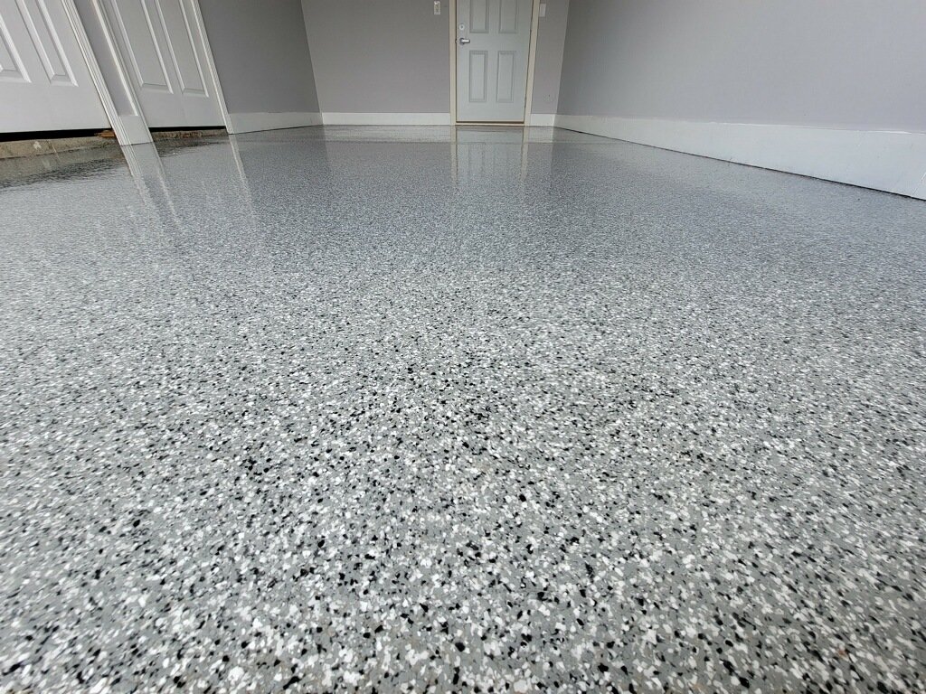 A high-gloss flake epoxy floor with a polyaspartic topcoat installed by All Out Coatings